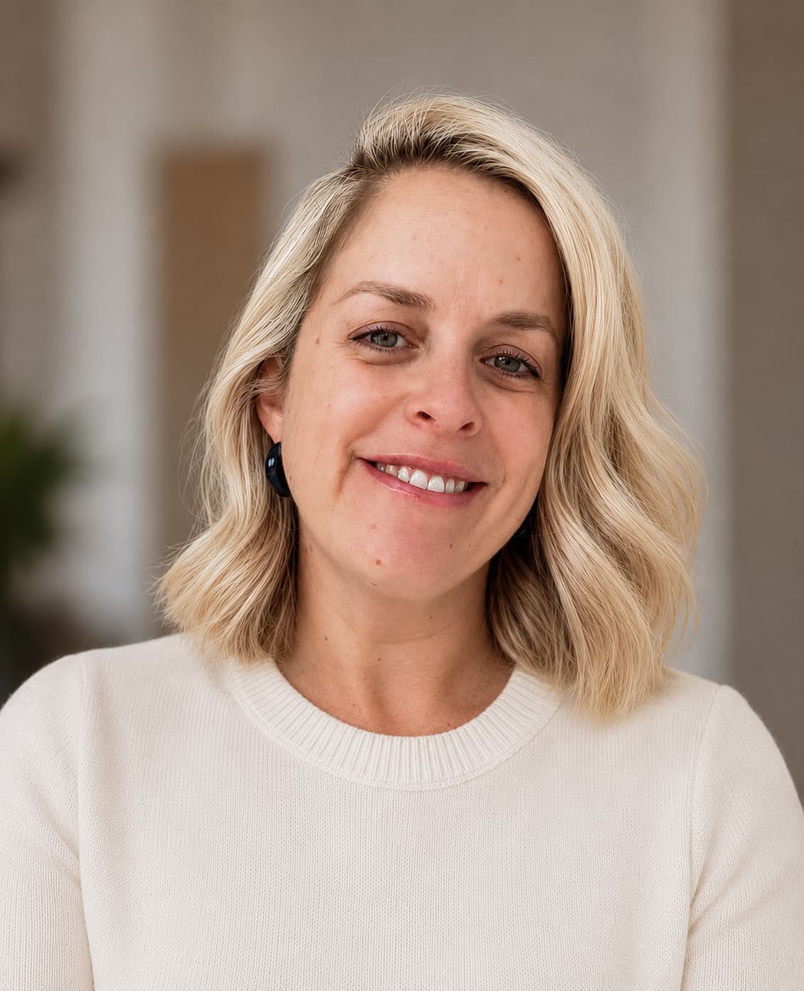Delphine, co-founder of Orla Bridal, smiling in a cream knit.