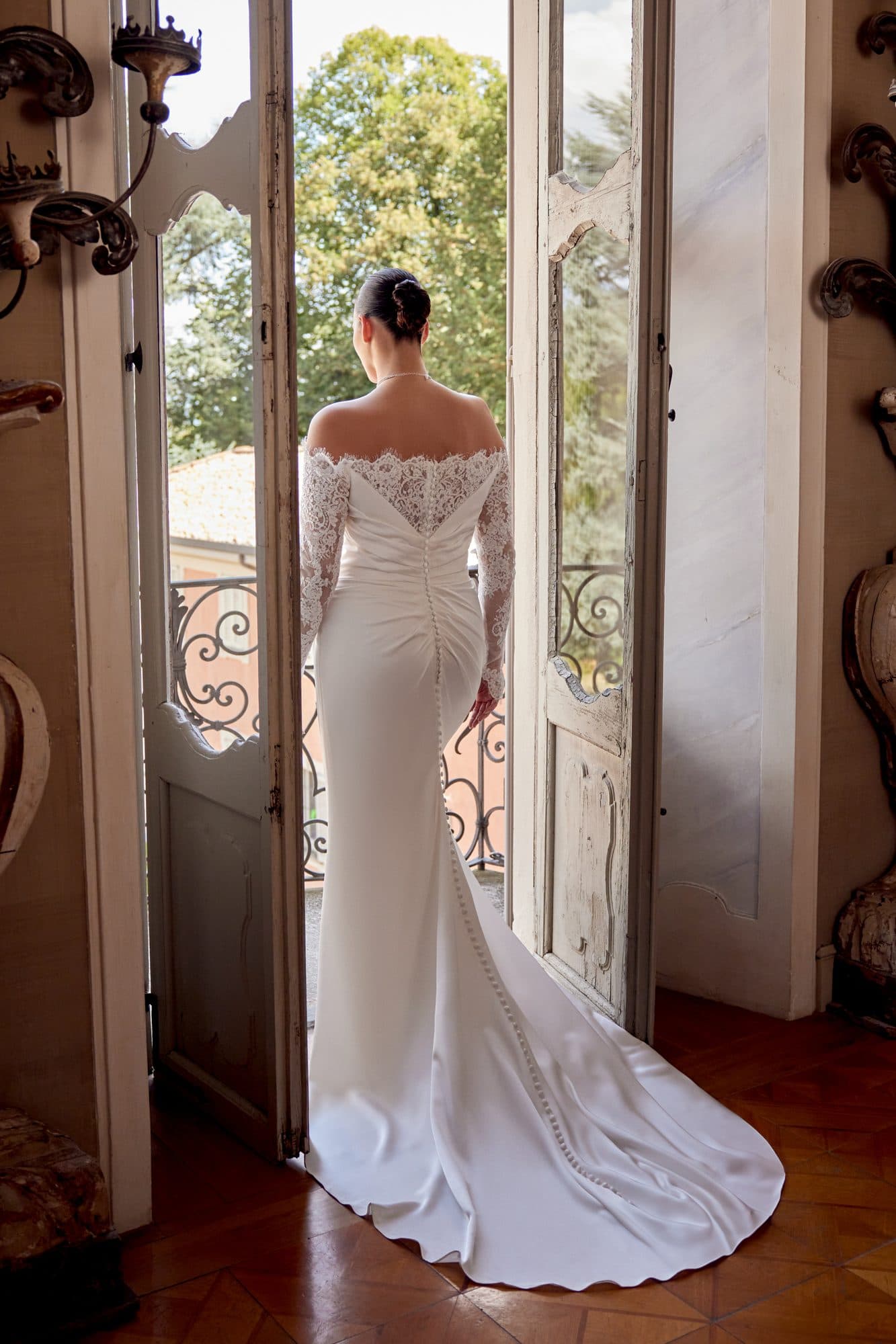 Back of the Justin Alexander Jessa gown showing its lace shoulders and buttoned crepe train.