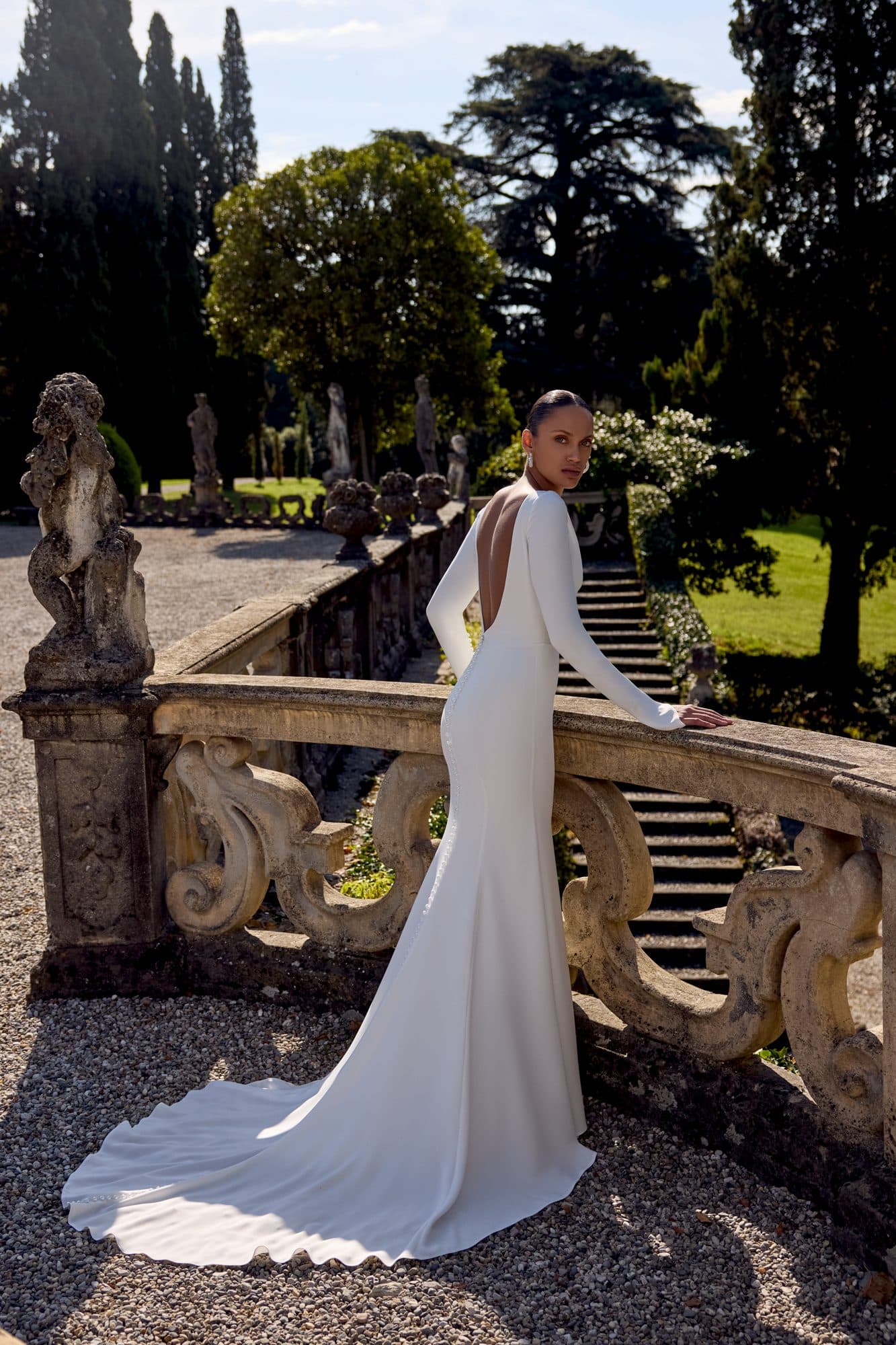 Back of the Justin Alexander Kathleen gown showing its deep open back and smooth crepe train.