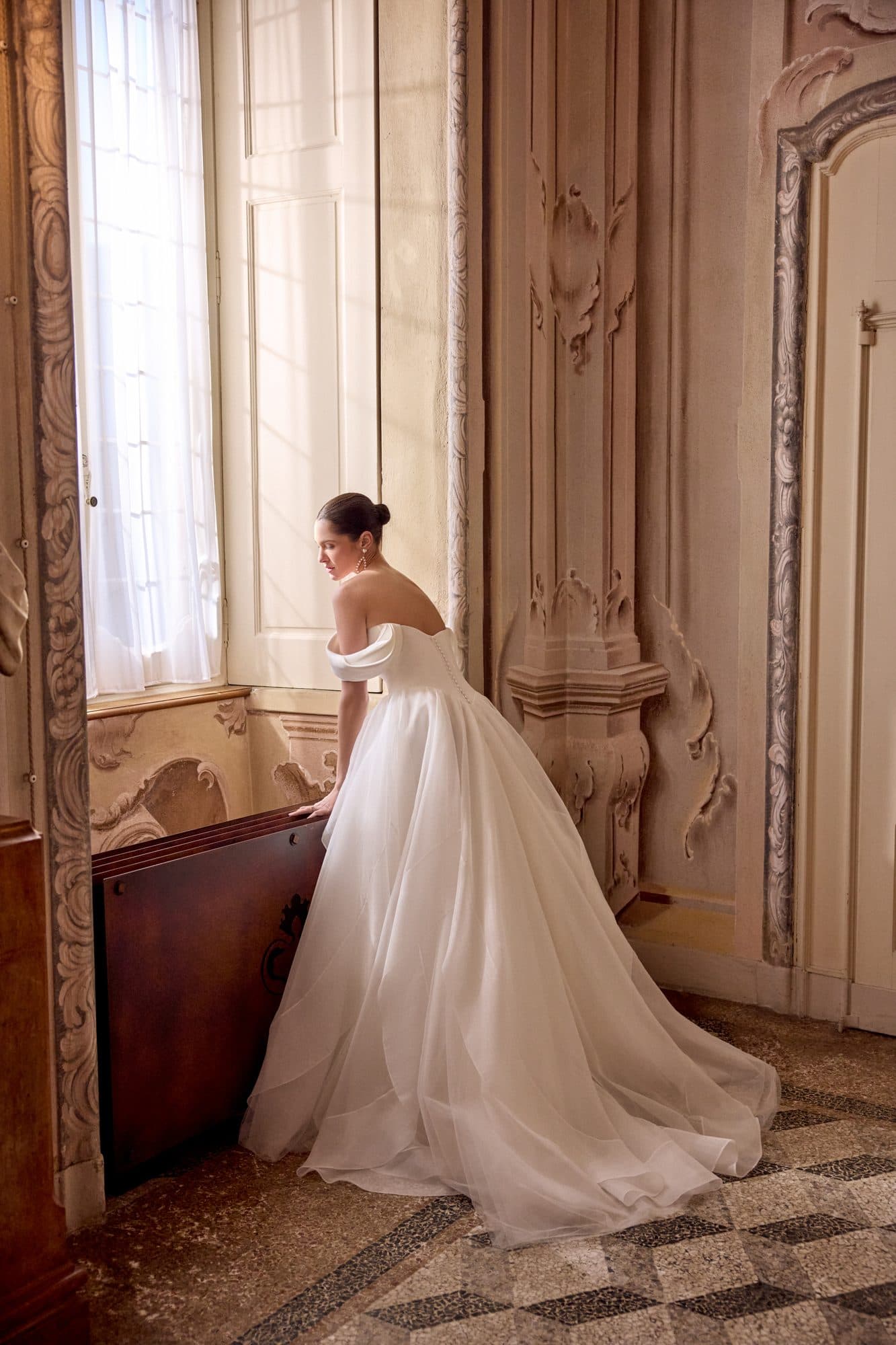 Back of the Justin Alexander Lyla gown showing its draped bodice and full organza train.