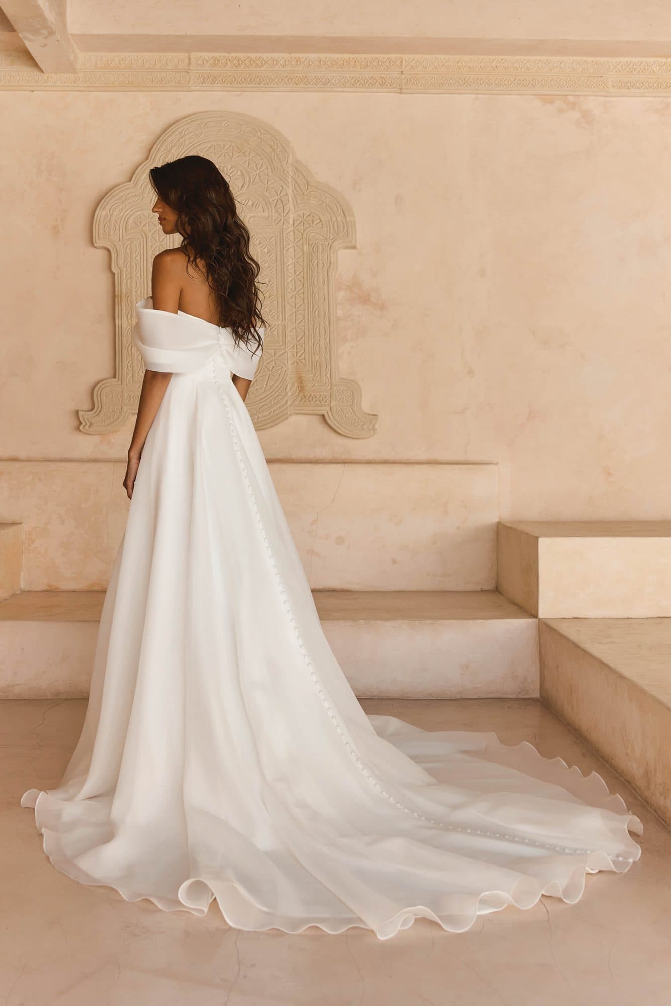 Back of the Madi Lane Lissy gown showing the draped off-the-shoulder band and soft organza train.