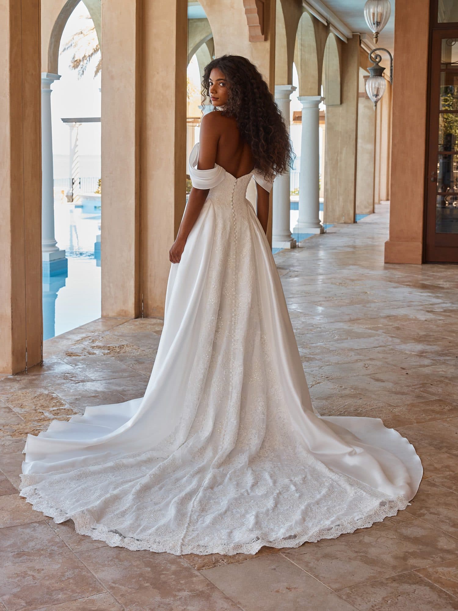 Back of the Madi Lane Olexa gown worn off the shoulder, showing its smooth satin train.