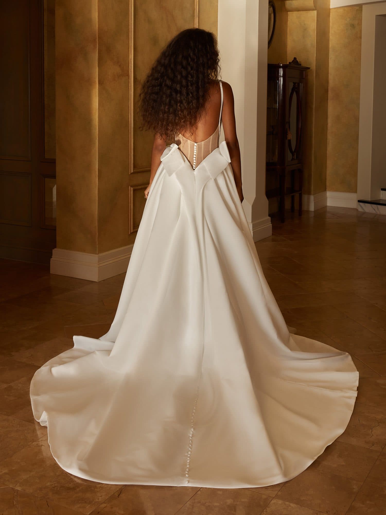 Back of the Madi Lane Osborne gown showing its clean low back and sweeping crepe train.