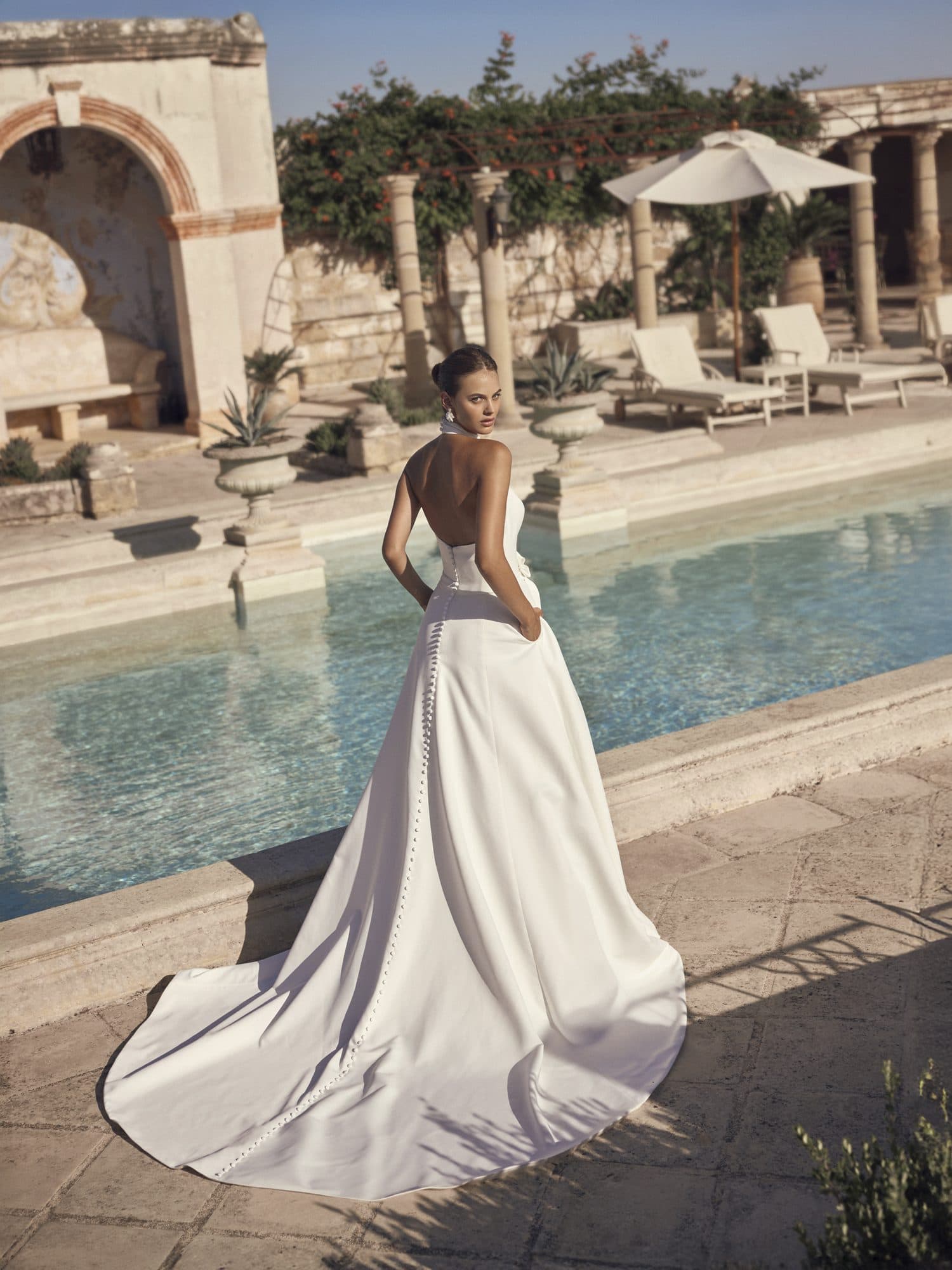 Back of the Modeca Marvina gown showing its low open back and sweeping crepe train.