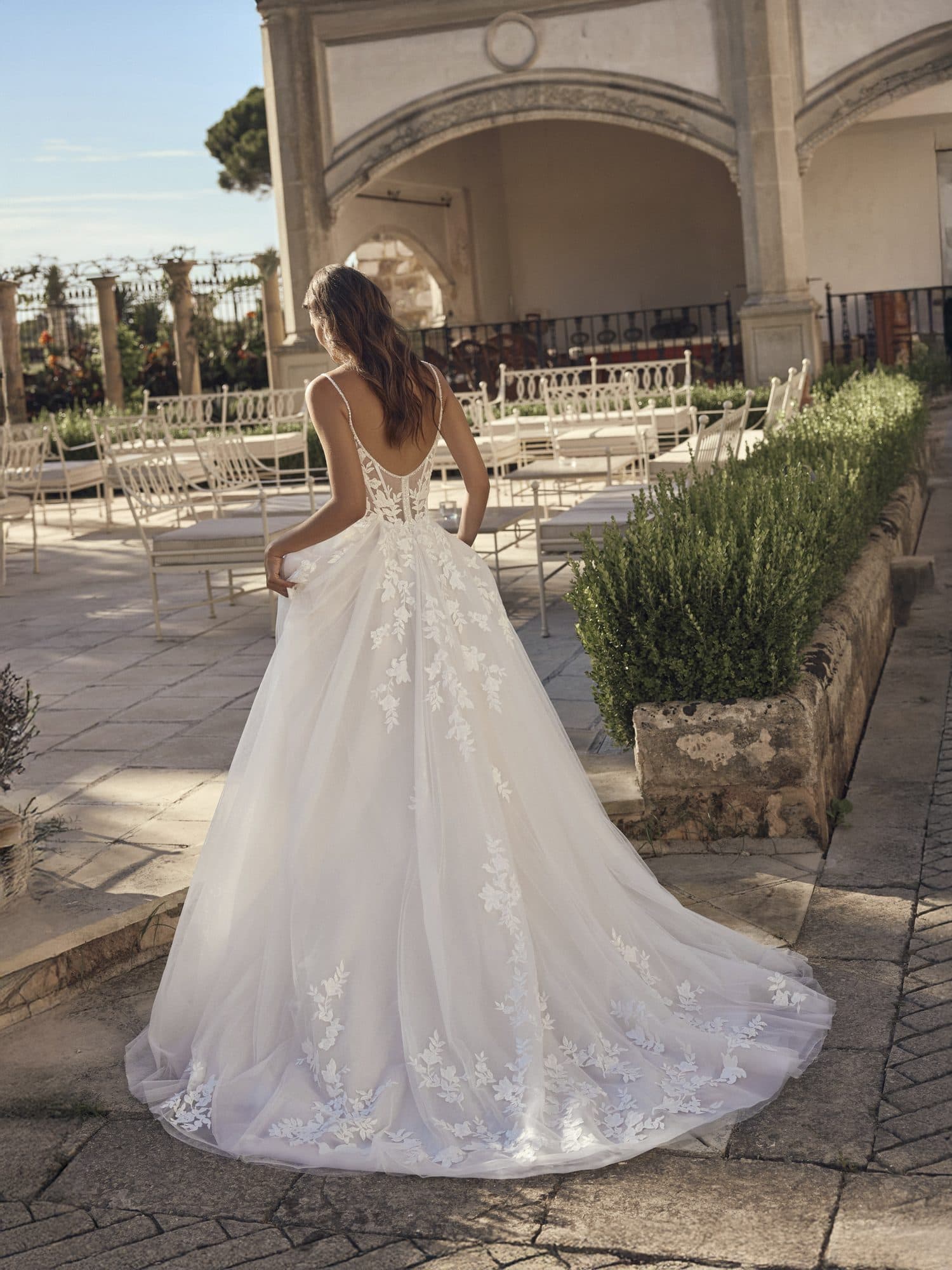 Back of the Modeca Moyra gown showing its low back and floating tulle train.